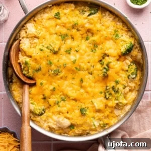 Ultimate Chicken Broccoli Rice Bake 12 cheesy chicken broccoli casserole in a skillet with a wooden spoon