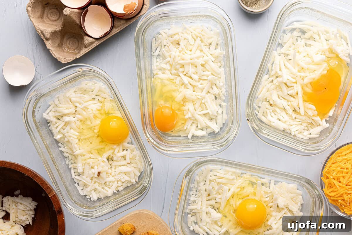 Chick-fil-A Inspired Hash Brown Breakfast Bowls 5 meal prep containers with hash browns and raw egg in each one, partially assembled