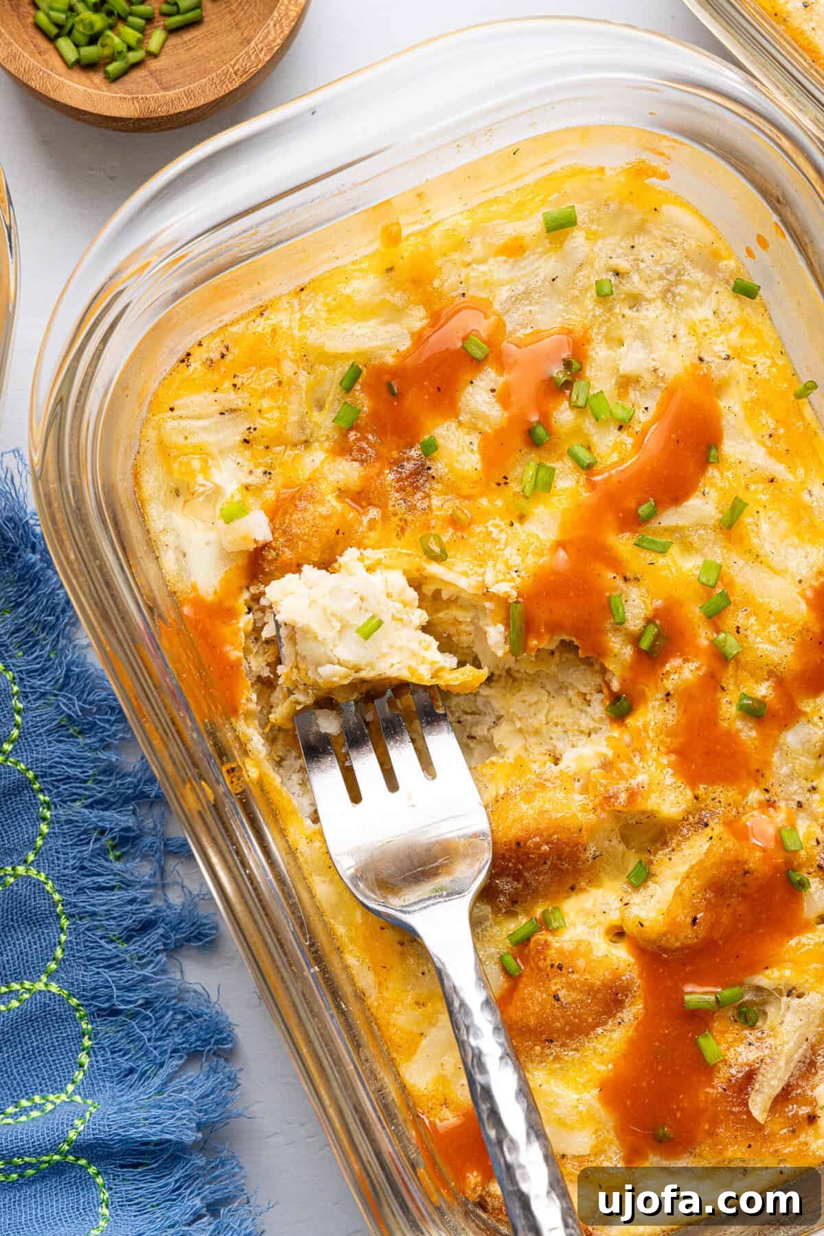 Chick-fil-A Inspired Hash Brown Breakfast Bowls 9 a close-up shot of a chick fil a copycat hash brown scramble bowl topped with hot sauce and fresh chives