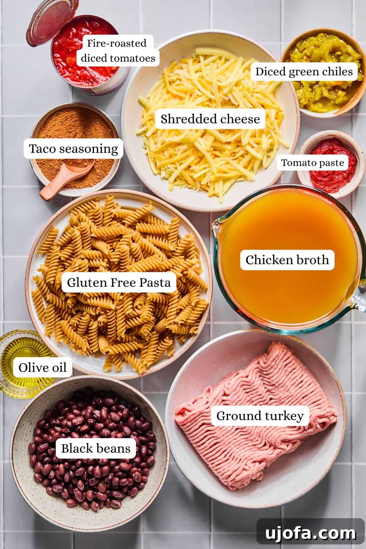 Ingredients for one pot taco pasta arranged in labeled nesting bowls, showcasing fresh and vibrant components.