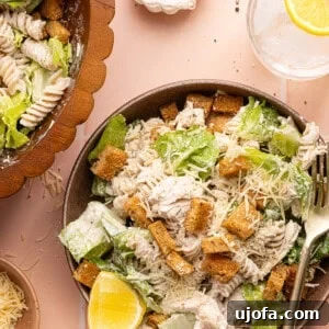chicken caesar pasta salad in a bowl with a silver fork