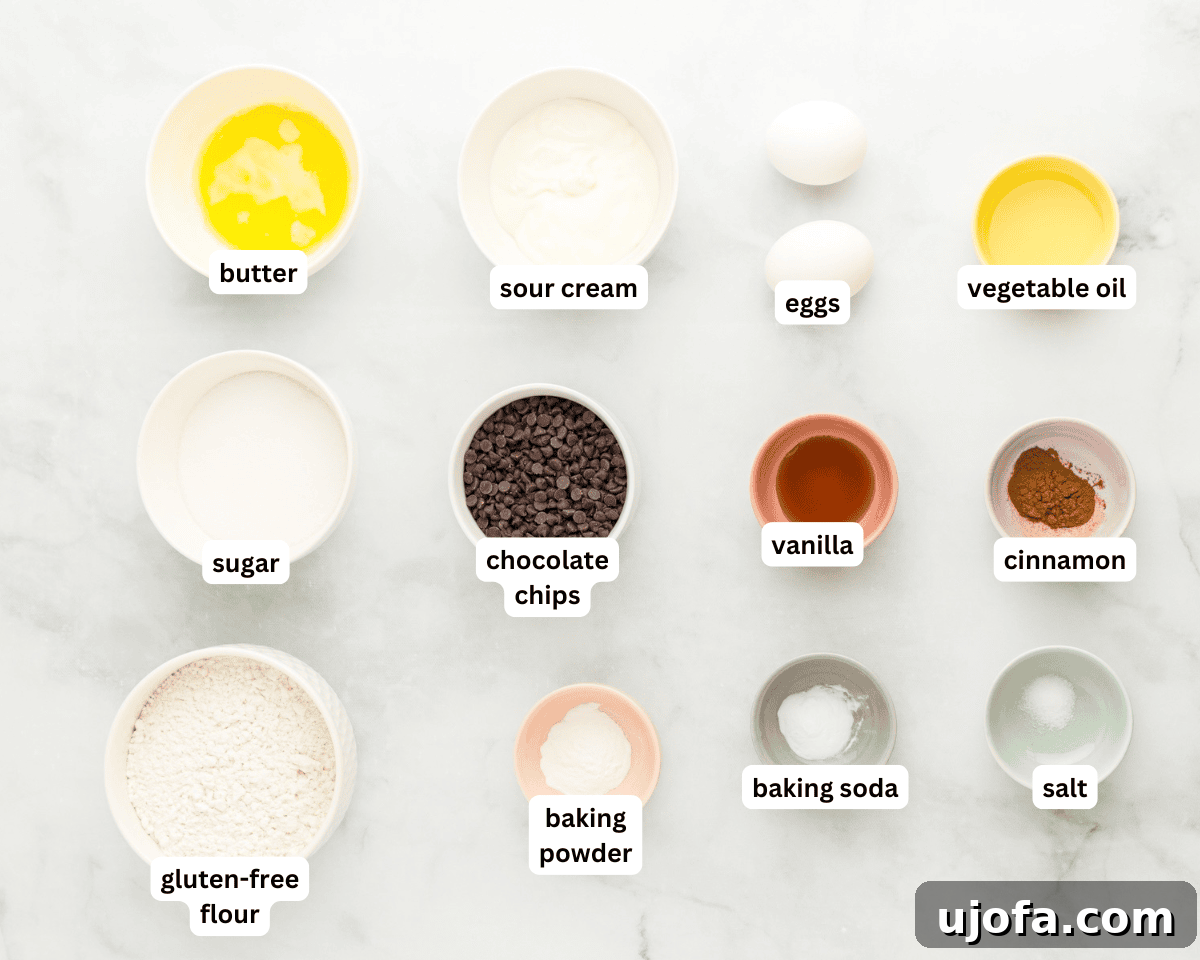 A flat lay of all the fresh ingredients needed for baking gluten-free chocolate chip muffins, neatly arranged on a rustic wooden surface.