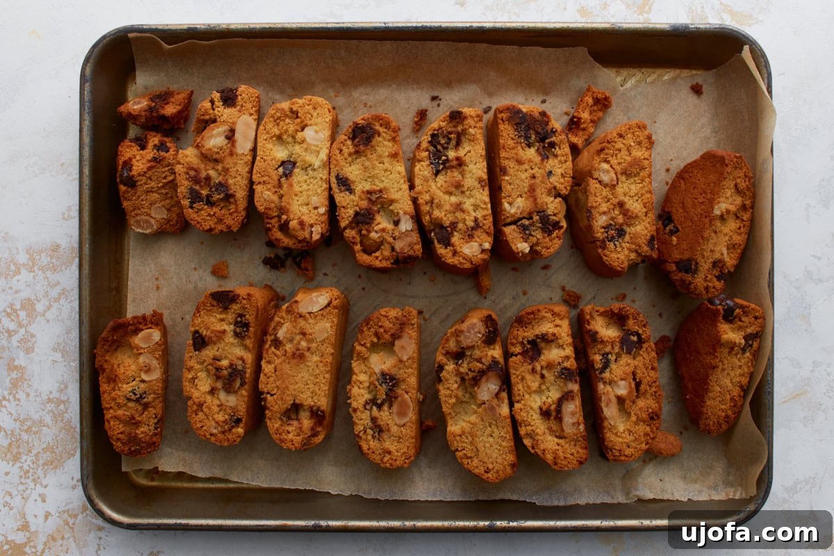Artisanal Almond Biscotti 9 Individual almond flour biscotti slices arranged cut-side down on a parchment-lined baking sheet, prepared for their second bake.