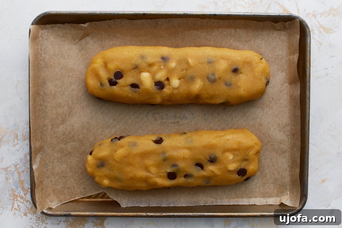 Artisanal Almond Biscotti 7 Two neatly shaped logs of almond flour biscotti dough resting on a parchment-lined baking sheet, ready for the first bake.