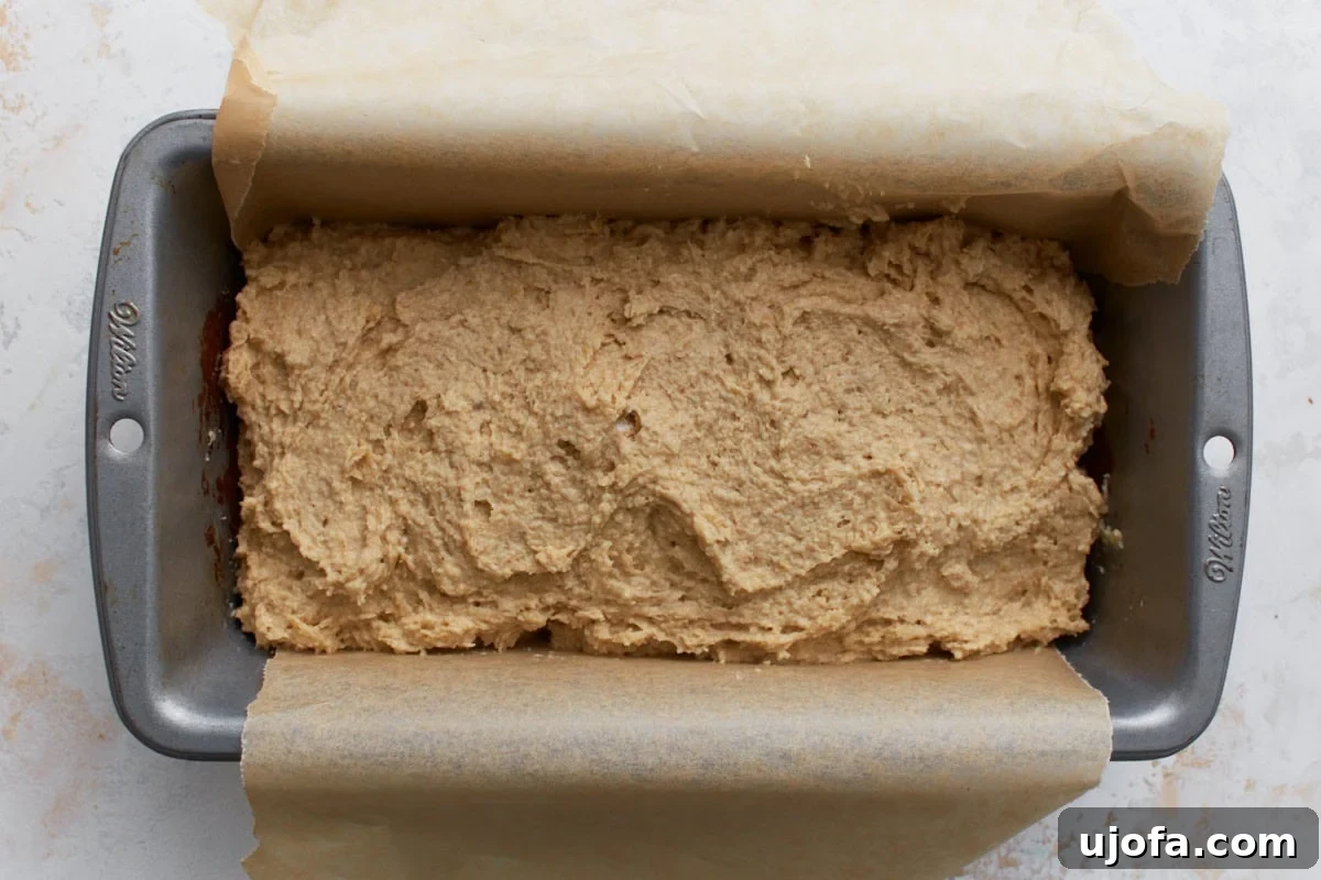 Wholesome Oat Bread 7 Oat flour bread batter spread into a parchment-lined loaf pan before baking