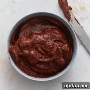 Creamy vegan Nutella in a bowl with a knife, showing thick, rich chocolate hazelnut spread texture