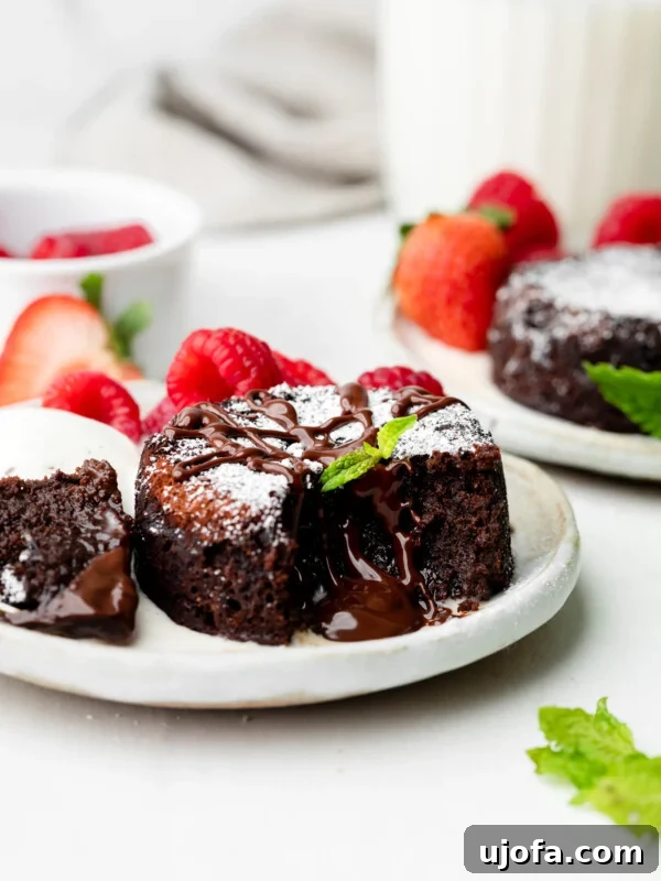 Gluten-Free Tiramisu Recipe: Authentic Italian Dessert Without Gluten 14 mini chocolate lava cake on a plate with mint leaves and raspberries and strawberries in the background