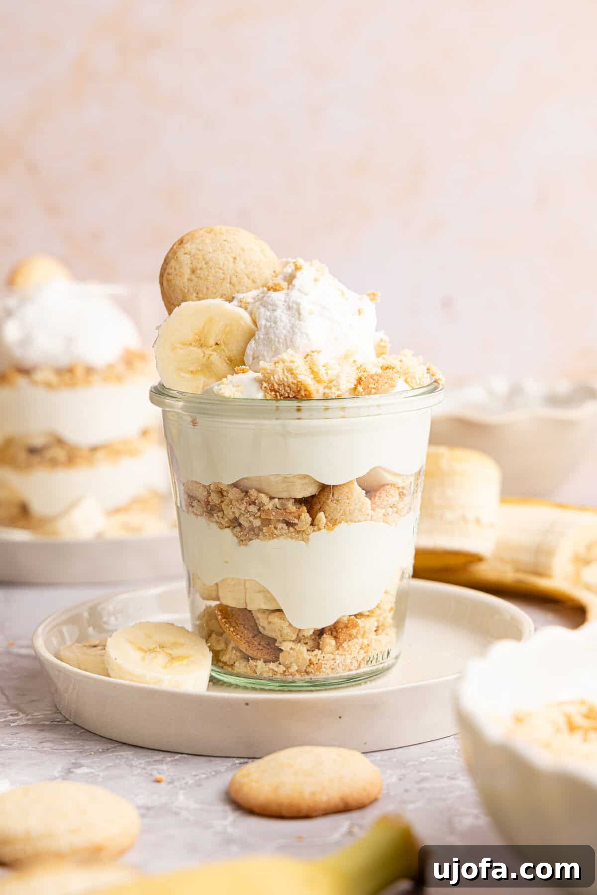 Protein-Packed Banana Pudding Cups for Muscle Fuel 2 a banana pudding cup with a vanilla wafer and whipped cream on top