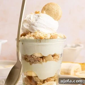 Protein-Packed Banana Pudding Cups for Muscle Fuel 14 a banana pudding cup with a spoon rested against the side on a plate
