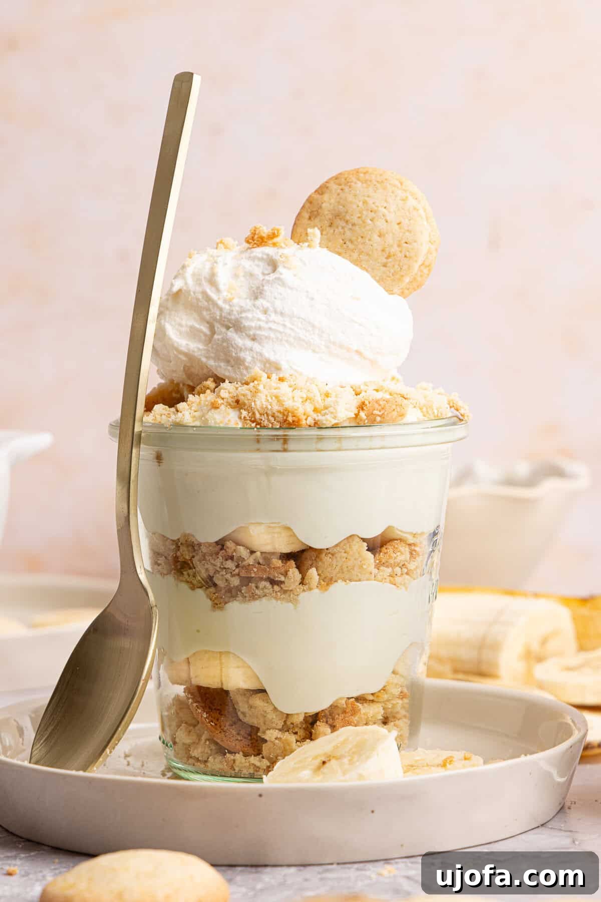 Protein-Packed Banana Pudding Cups for Muscle Fuel 8 a banana pudding cup with a spoon rested against the side on a plate