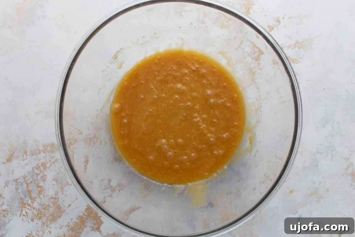 Egg and vanilla whisked into the melted butter and sugar mixture until smooth and glossy