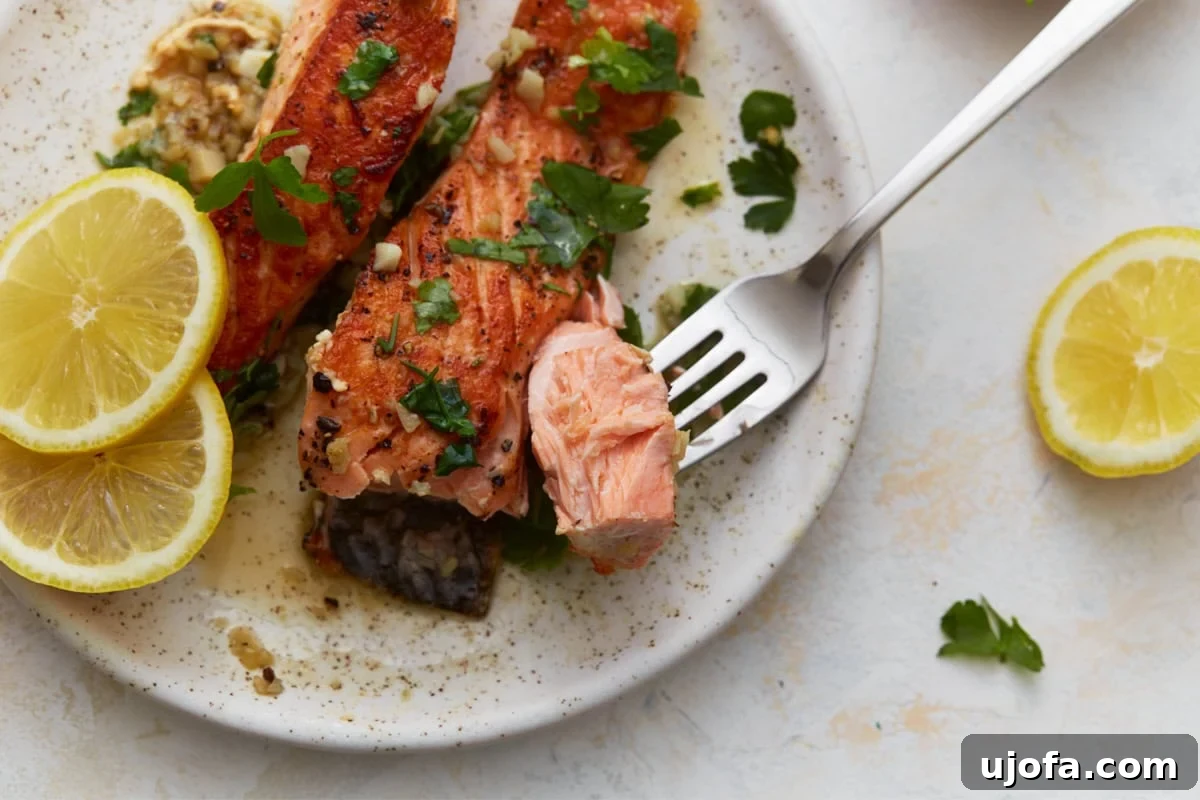 Keto Salmon in Garlic Butter Lemon Sauce 10 Close-up of flaky keto salmon being cut with a fork showing tender texture