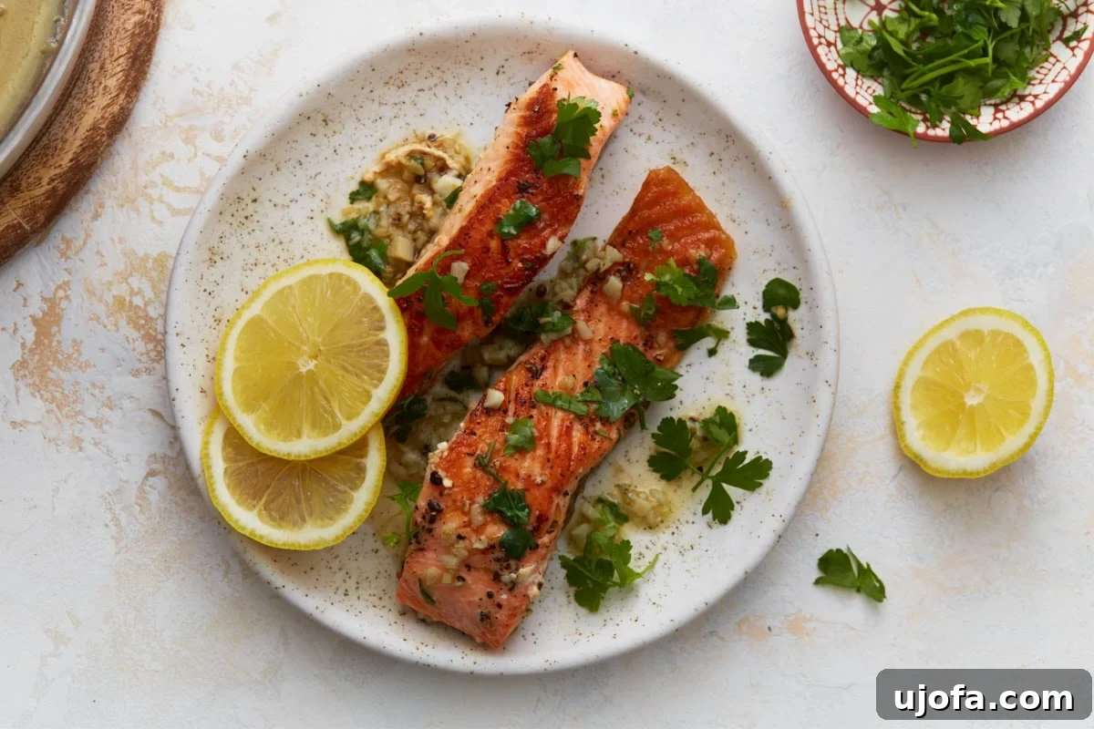 Keto Salmon in Garlic Butter Lemon Sauce 9 Garlic butter salmon plated with lemon slices and fresh herbs