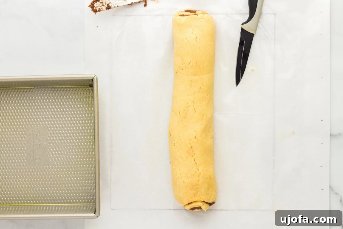 Rolled cinnamon dough log before slicing into rolls