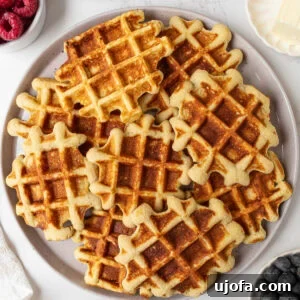 Coconut Flour Waffles: Light, Crispy Grain-Free Recipe 3 Plate of golden brown gluten-free coconut flour waffles served with fresh berries, butter, and maple syrup