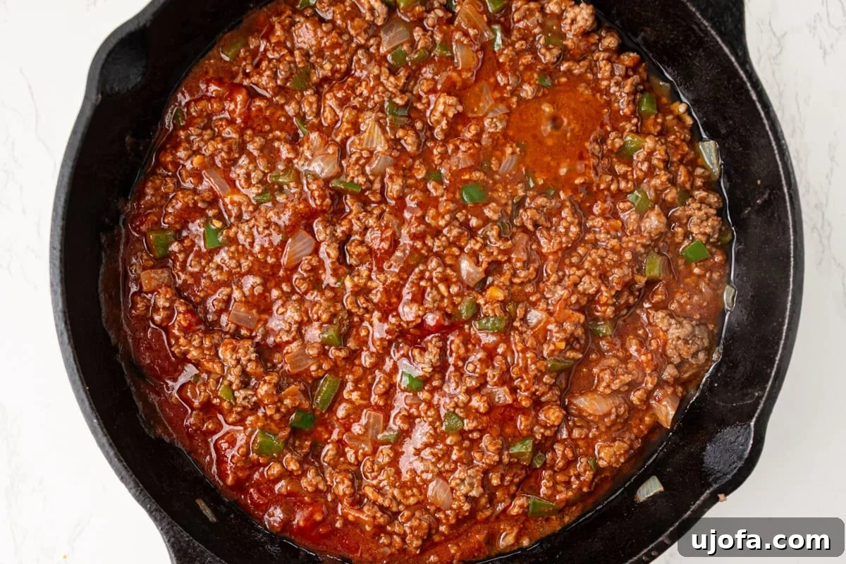 Sloppy joe meat mixture with tomato sauce added in a skillet