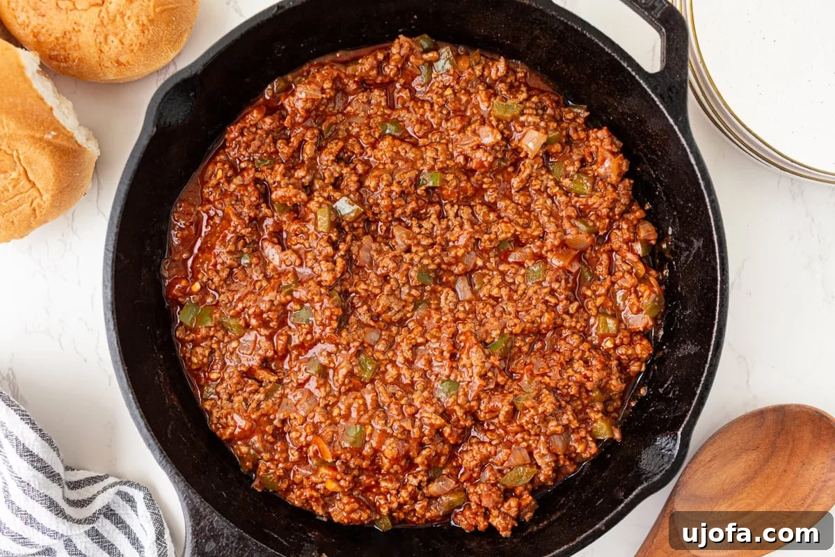 Sloppy joe mixture simmering in a cast iron skillet until thick and saucy