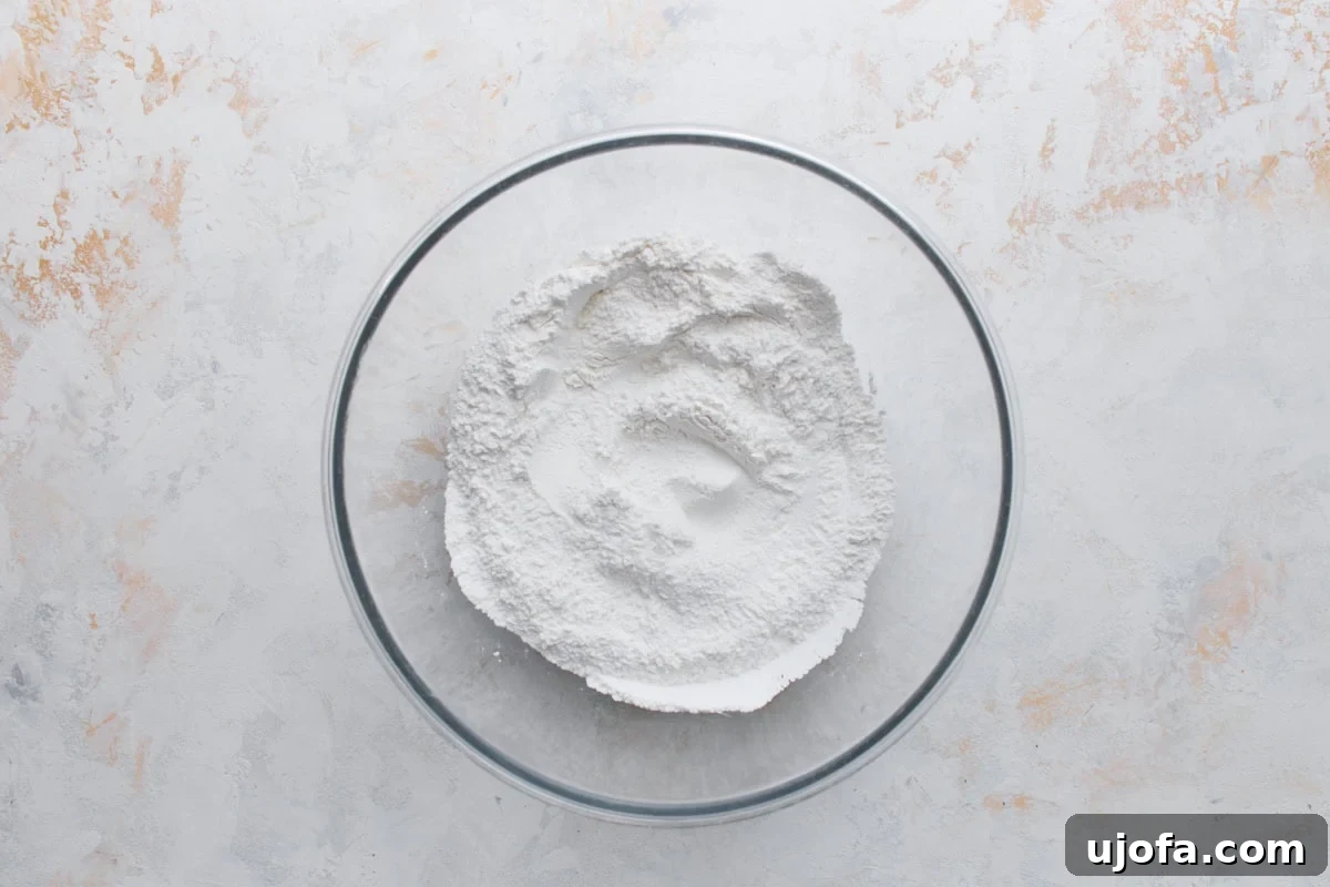 Gluten-Free Mochi Donuts Recipe: Chewy, Crispy & Irresistible 6 Glutinous rice flour mixture for gluten-free mochi donuts in a glass mixing bowl