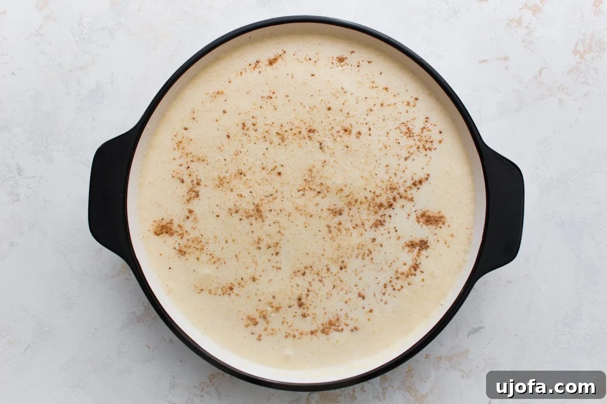 Silky Crustless Custard Pie Recipe: Creamy Baked Custard Delight 6 Unbaked crustless custard pie filling sprinkled with nutmeg in a pie dish
