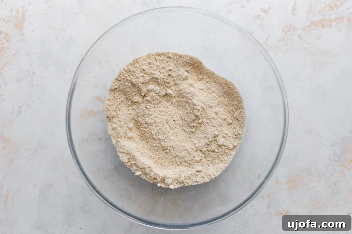Crispy Oat Flour Waffles Recipe for Fluffy Homemade Waffles 5 Dry oat flour waffle ingredients mixed together in a glass bowl.