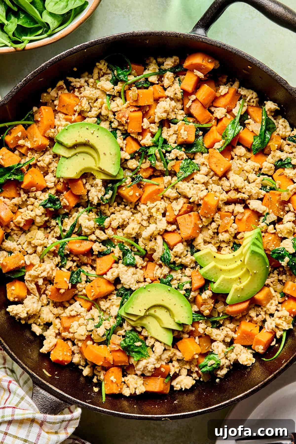 One-Skillet Turkey and Sweet Potato Hash Recipe 2 turkey sweet potato hash topped with avocado in a cast iron skillet