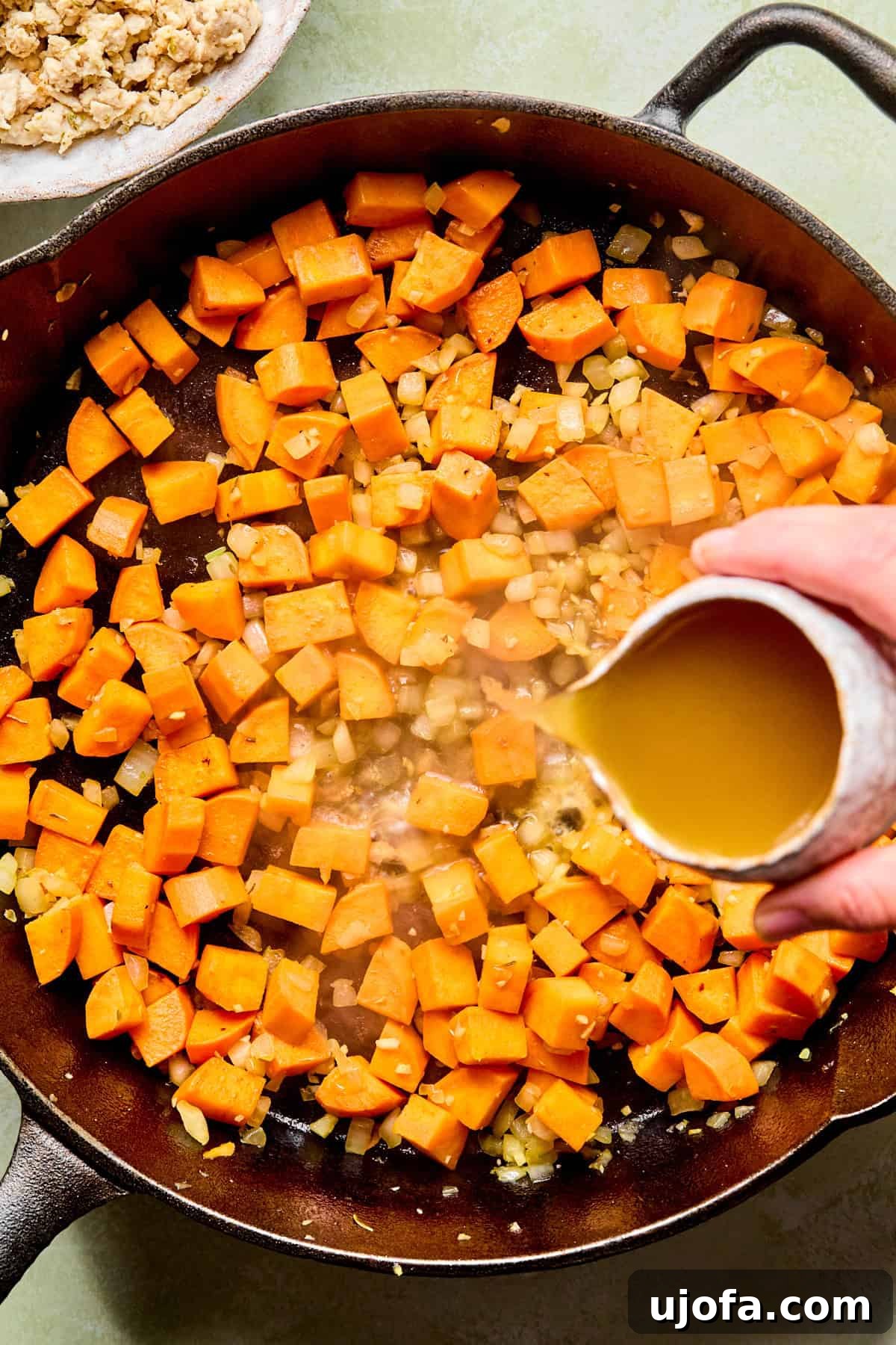 One-Skillet Turkey and Sweet Potato Hash Recipe 5 sweet potatoes in a skillet with broth being poured in