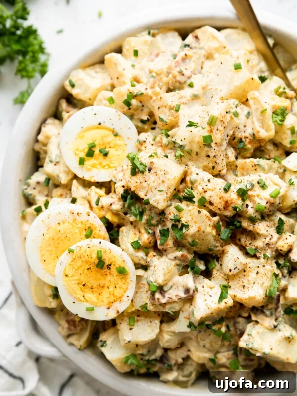 Gluten-Free Italian Pasta Salad Recipe for Flavorful Picnics 10 a close up of a bowl of deviled egg whole30 potato salad tossed with chives and parsley with two sliced hard boiled eggs on top