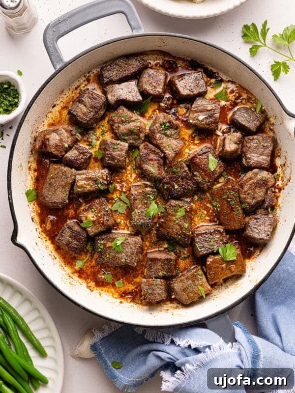 steak bites in a pan with garlic, butter, and parsley