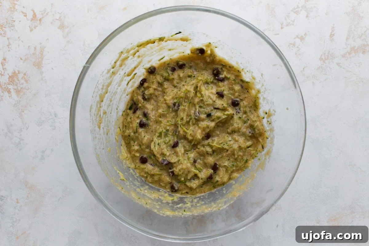 Overhead view of almond flour zucchini bread batter with grated zucchini and chocolate chips folded in