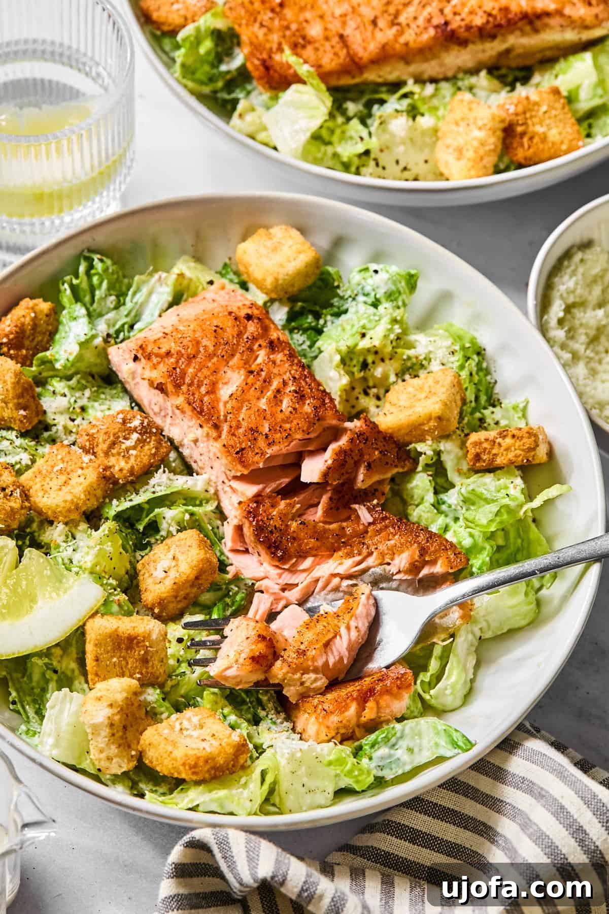 Protein-Packed Salmon Caesar with Creamy Dressing 12 a side view of salmon caesar salad with a fork breaking apart the salmon