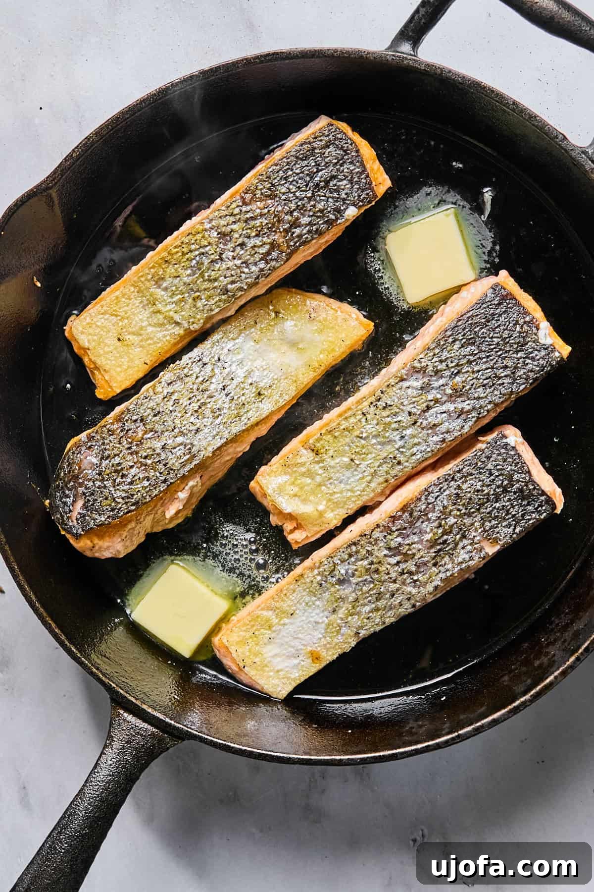 Protein-Packed Salmon Caesar with Creamy Dressing 8 butter in a skillet with 4 salmon fillets