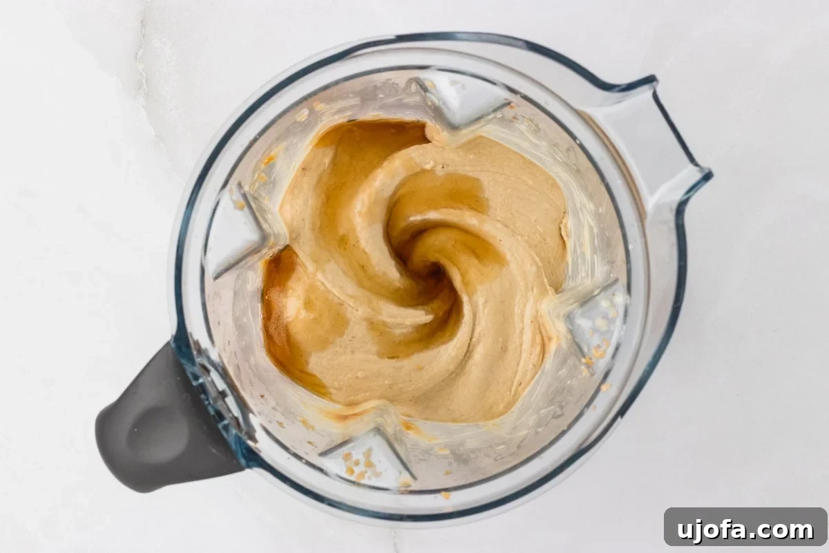 Overhead view of smooth and creamy blended banana peanut butter nice cream mixture in a blender