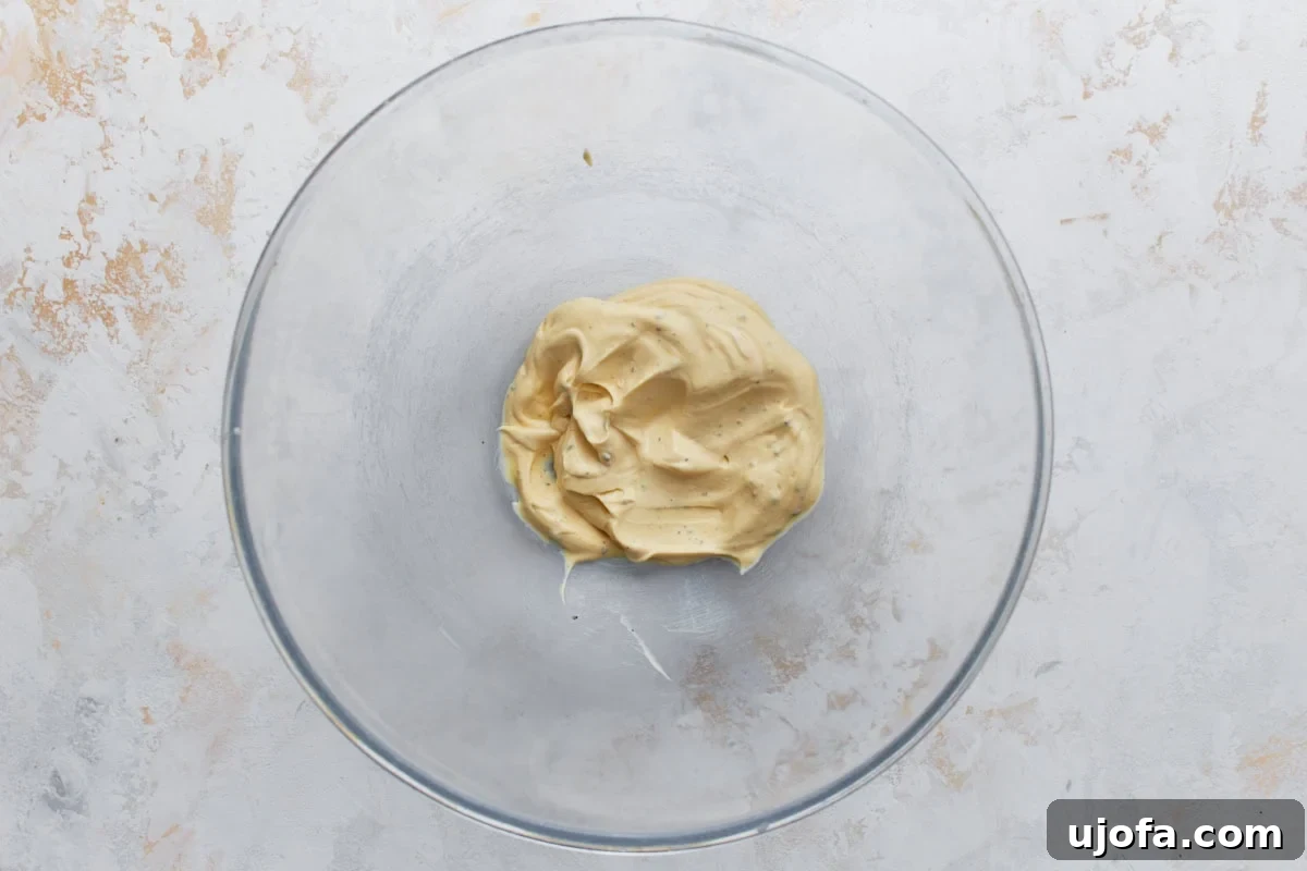 Creamy Keto Chicken Salad with Bacon and Avocado 4 Creamy Dijon mayo dressing for keto chicken salad in a glass mixing bowl.