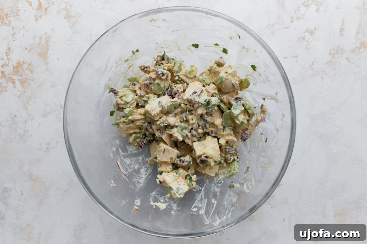Creamy Keto Chicken Salad with Bacon and Avocado 5 Keto chicken salad with chicken, pecans, celery, and red onion mixed together in a glass bowl.
