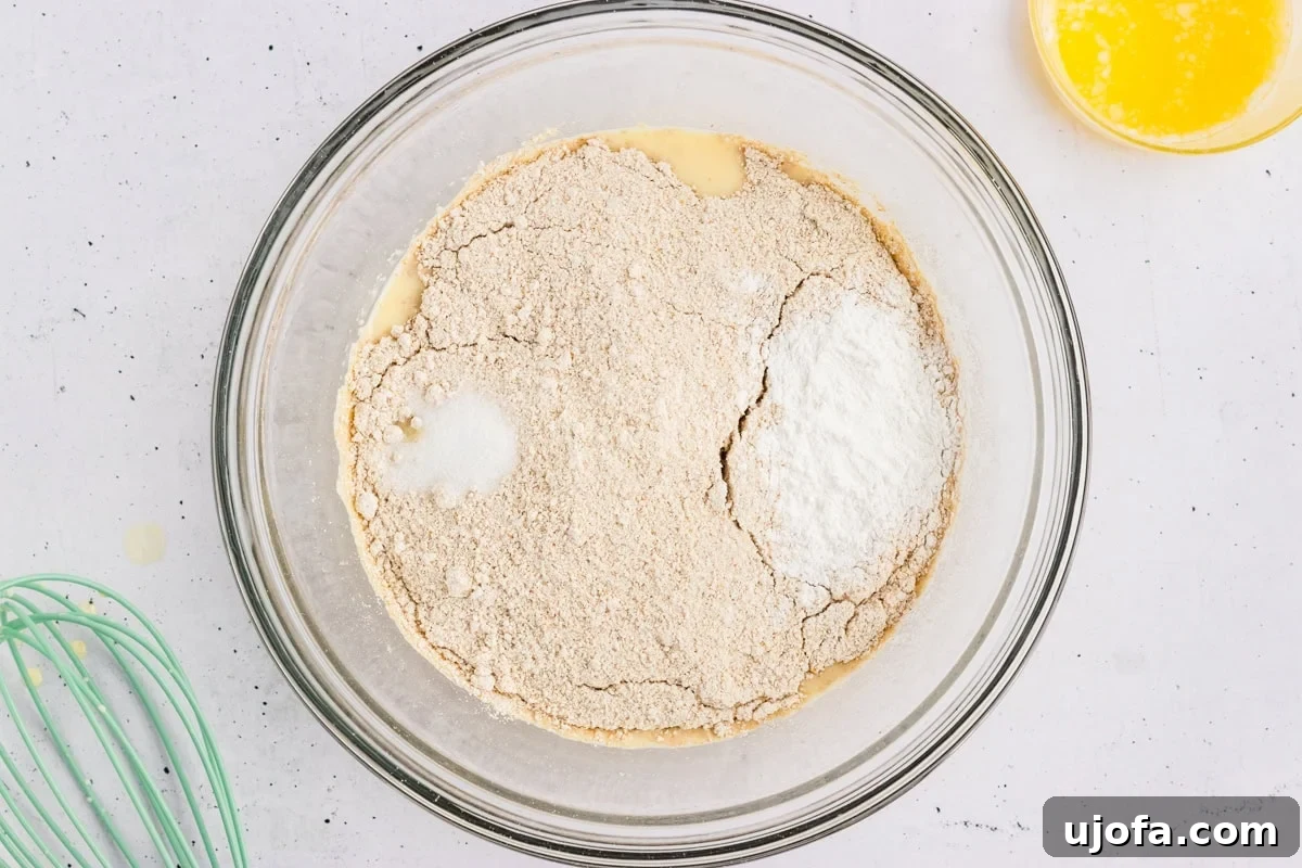 Fluffy Oat Flour Pancakes Recipe 5 Oat flour, baking powder, and salt added on top of the whisked wet ingredients in a glass mixing bowl.