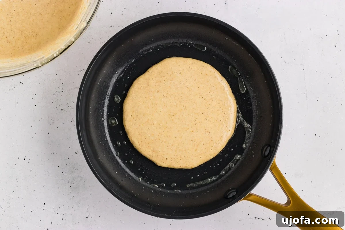 Fluffy Oat Flour Pancakes Recipe 8 Oat flour pancake batter poured into a hot skillet.