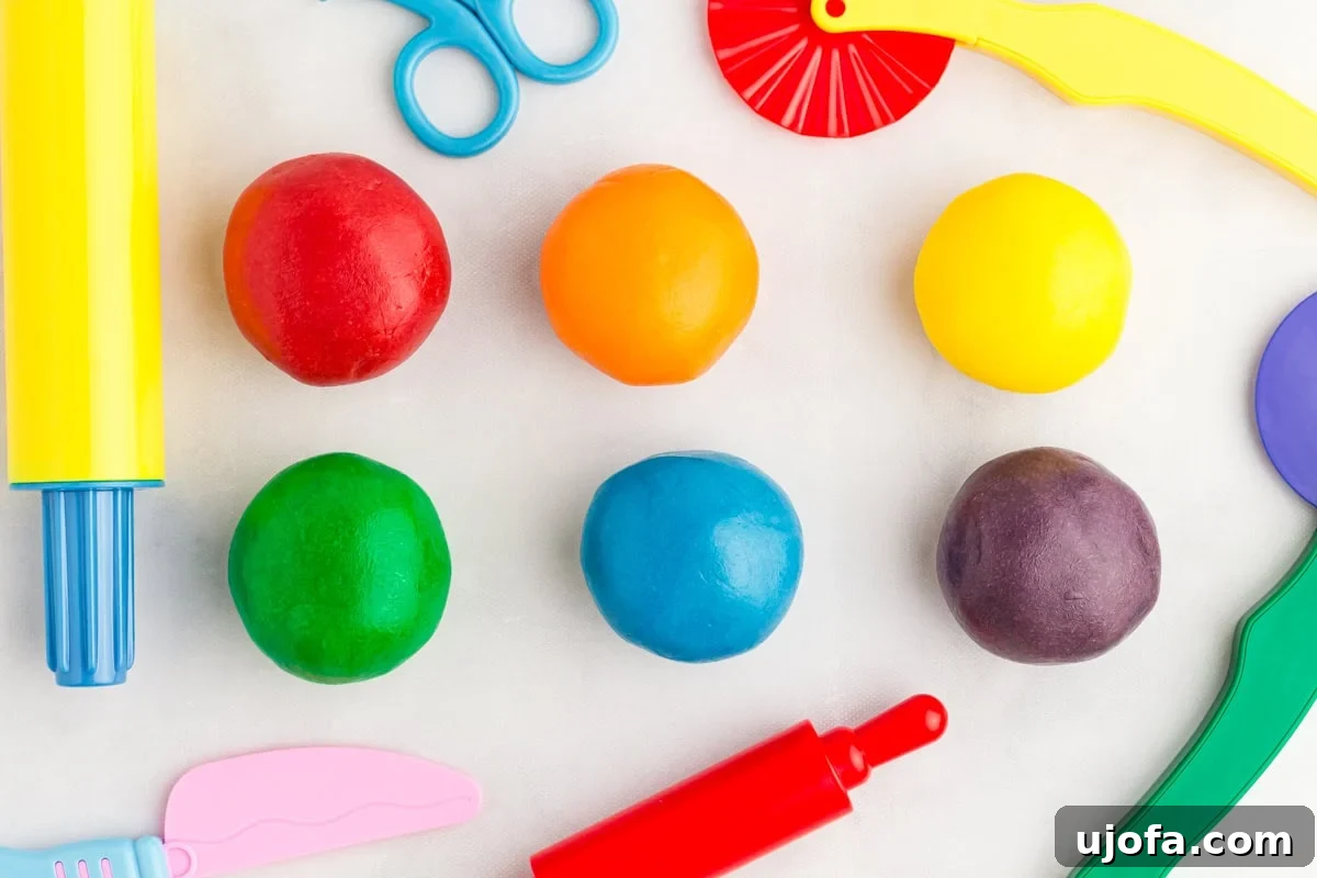 Homemade Gluten-Free Play Dough Recipe for Kids 9 six colorful dough discs stacked together with play doh tools in the background
