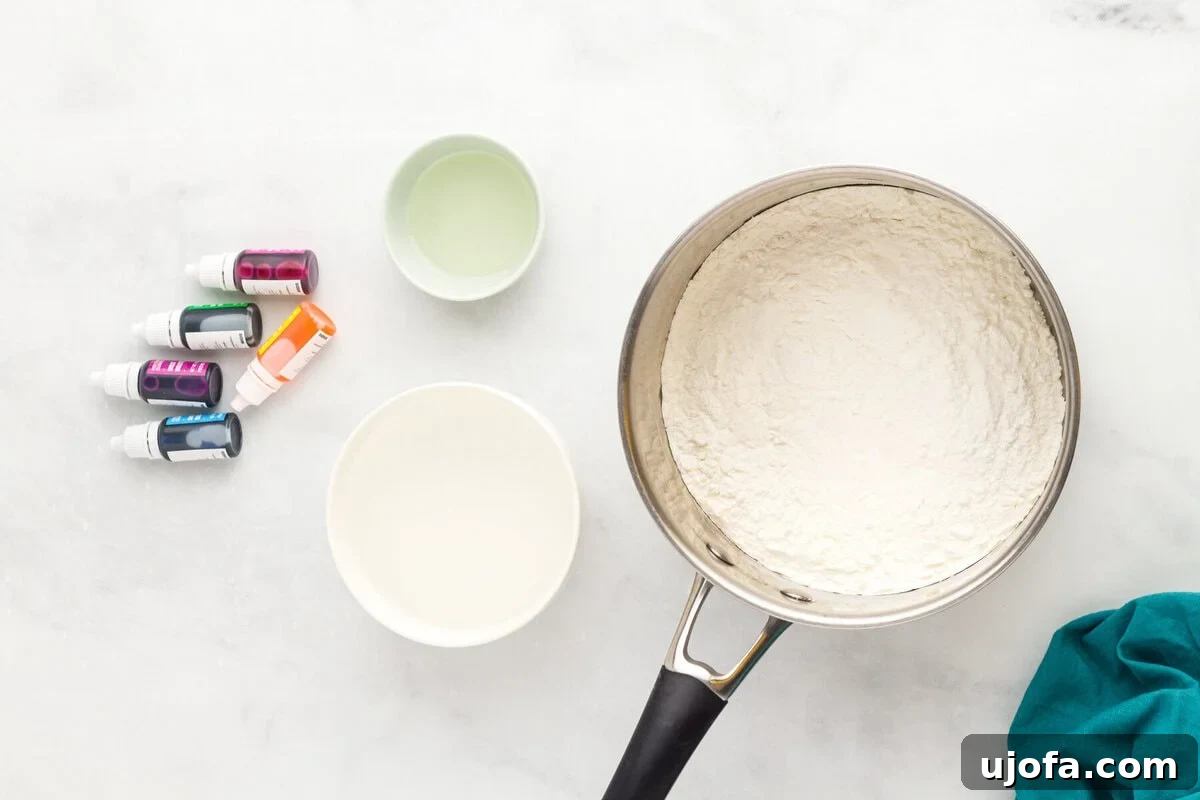Homemade Gluten-Free Play Dough Recipe for Kids 5 flour mixture in a pot with bowls of water and oil, and food coloring bottles nearby