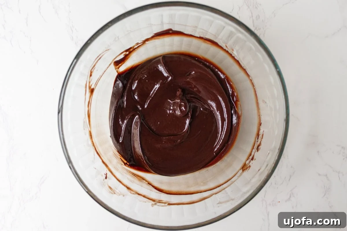 Gluten-Free Cosmic Brownies: Little Debbie Copycat Recipe 9 Smooth, glossy chocolate ganache in a glass bowl after melting and stirring.