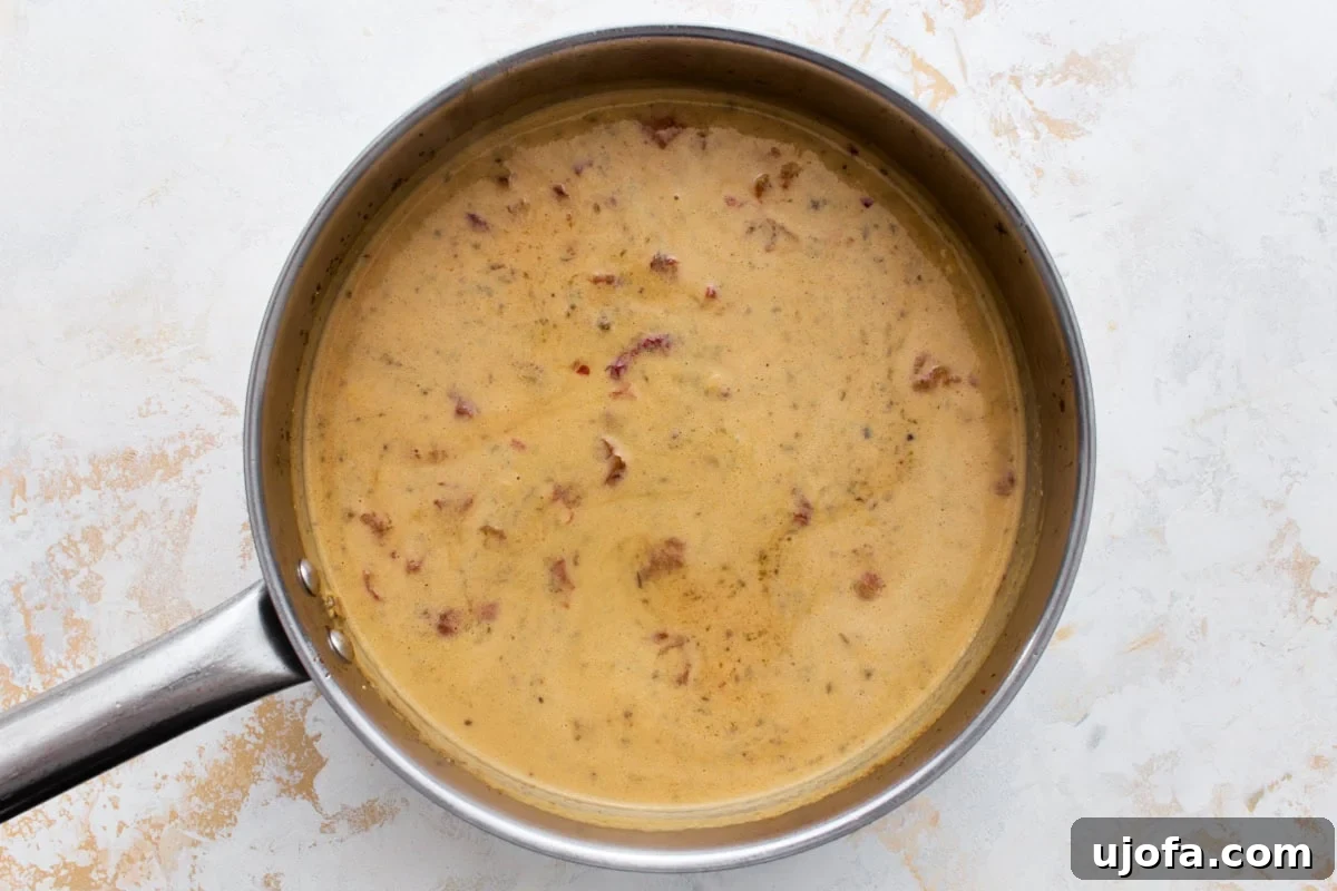 Dairy-Free Marry Me Chicken with Sun-Dried Tomato Sauce 9 Creamy dairy-free Marry Me Chicken sauce simmering in a skillet until thickened, before the chicken is added back.