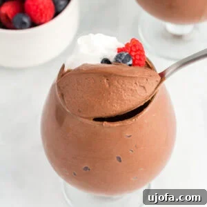 Delicious Gluten-Free and Dairy-Free Dessert Recipes 8 A glass filled with vegan chocolate mousse topped with whipped coconut cream and fresh berries.
