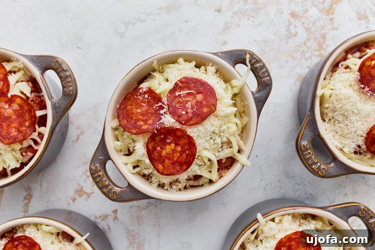 Crustless Pizza Bowl Recipe: Cheesy Pepperoni and Marinara 8 Mini ramekins topped with shredded mozzarella, Parmesan, and pepperoni before baking.