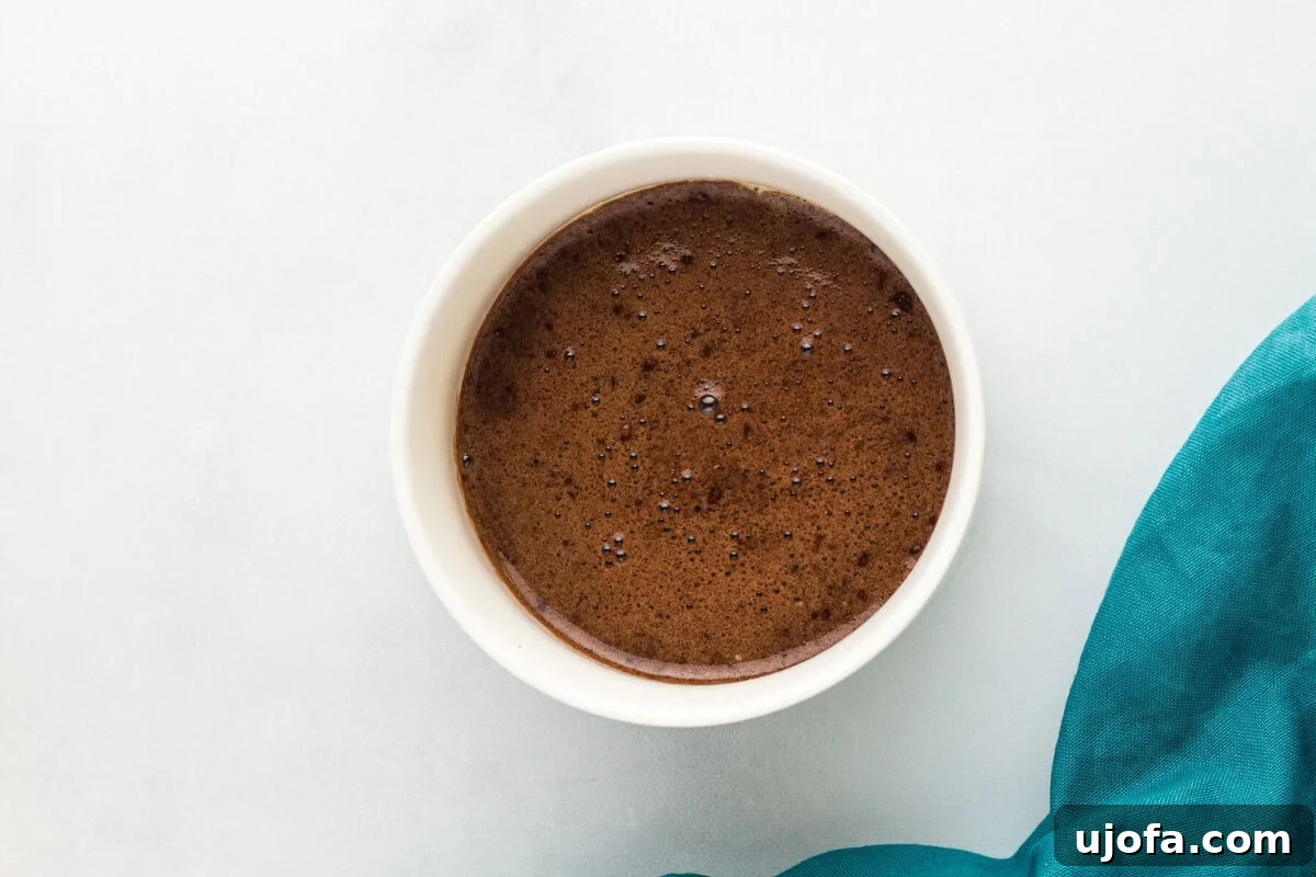 Microwave Flourless Chocolate Mug Cake 4 Overhead view of a flourless mug cake in a white ramekin, fresh out of the microwave